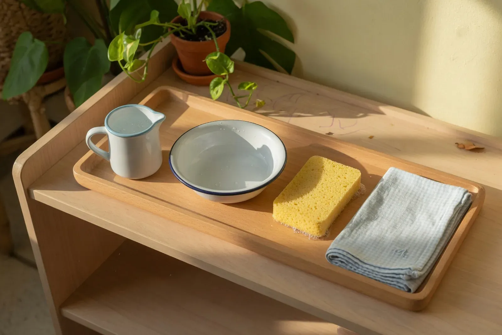 Child-sized pitcher and glass set on a practical life tray